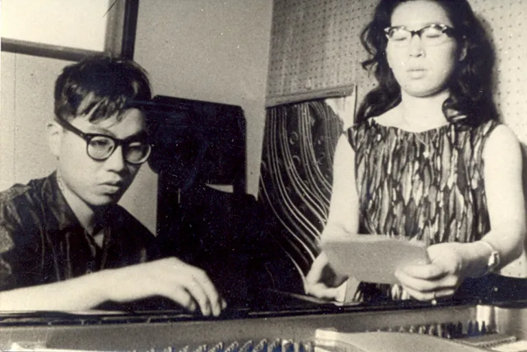 Tomohisa Nakajima e sua esposa Mie operando os cartões da Instrução 62 ao piano